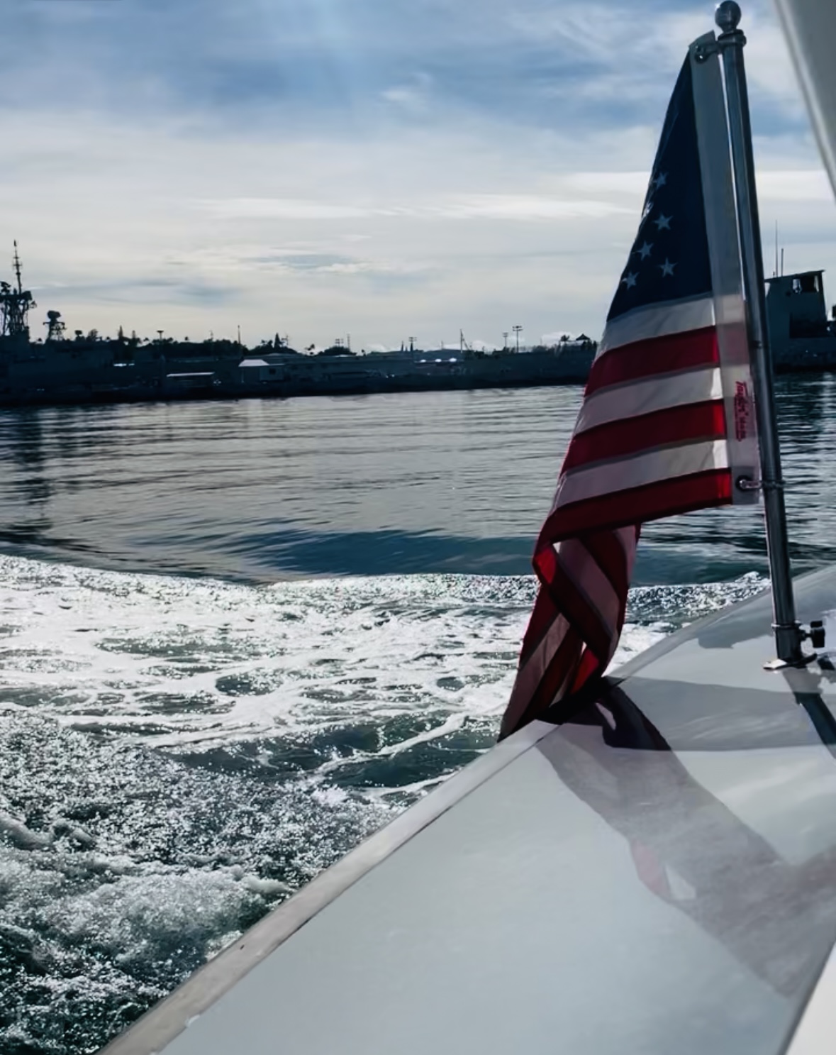 US flag over the side of a boat going to the memorial at Pearl Harbor.